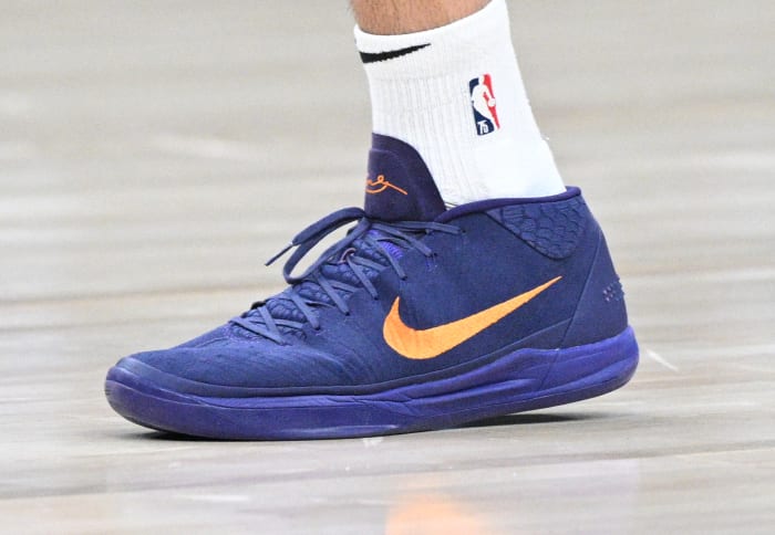 View of Devin Booker's purple and orange Nike shoes.